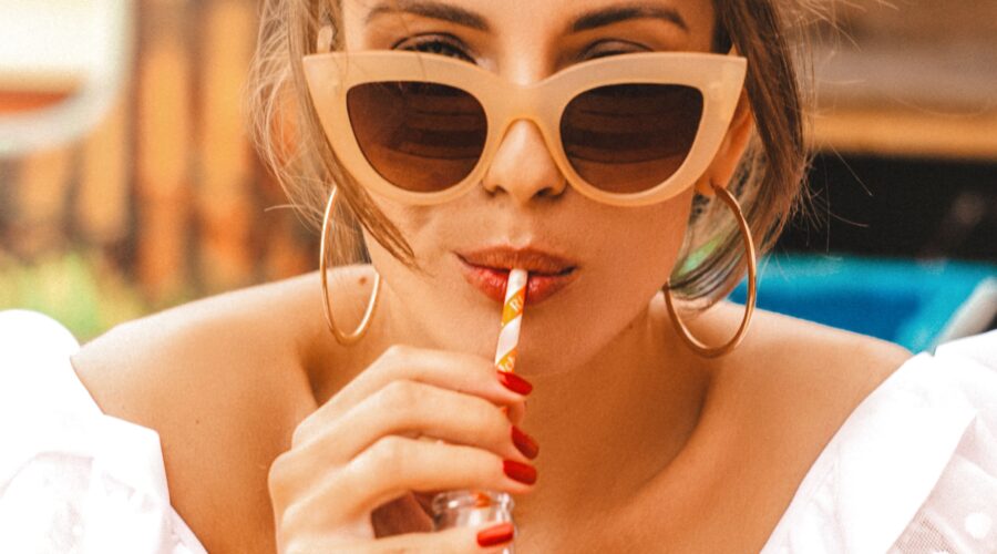 woman drinking out of a straw which is aging her upper lip